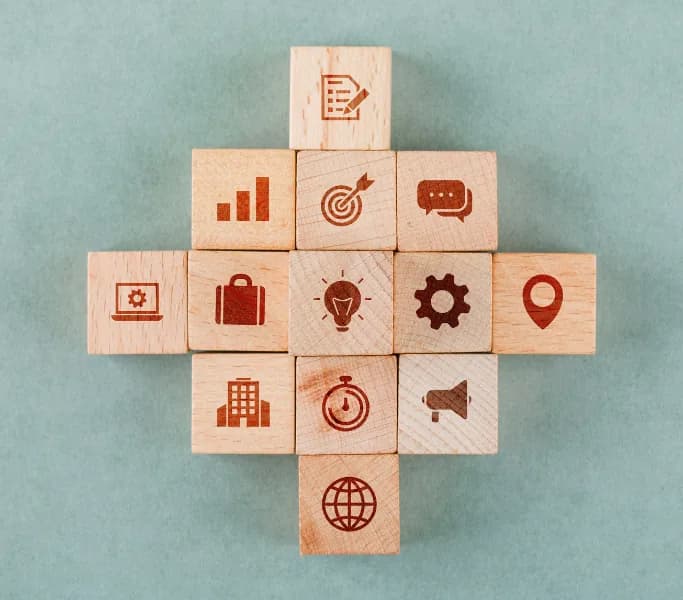 Wooden blocks with icons for marketing goals, communication and metrics